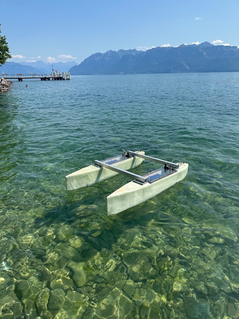 Le catamaran drone maritime à l'eau sur le Léman, devant les montagnes